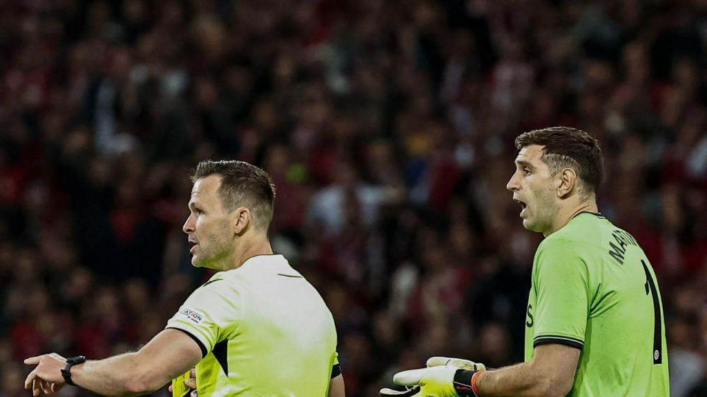 Emiliano Martínez e o árbitro do encontro entre o Lille e o Aston Villa, da Liga Europa (Photo by SAMEER AL-DOUMY/AFP via Getty Images)