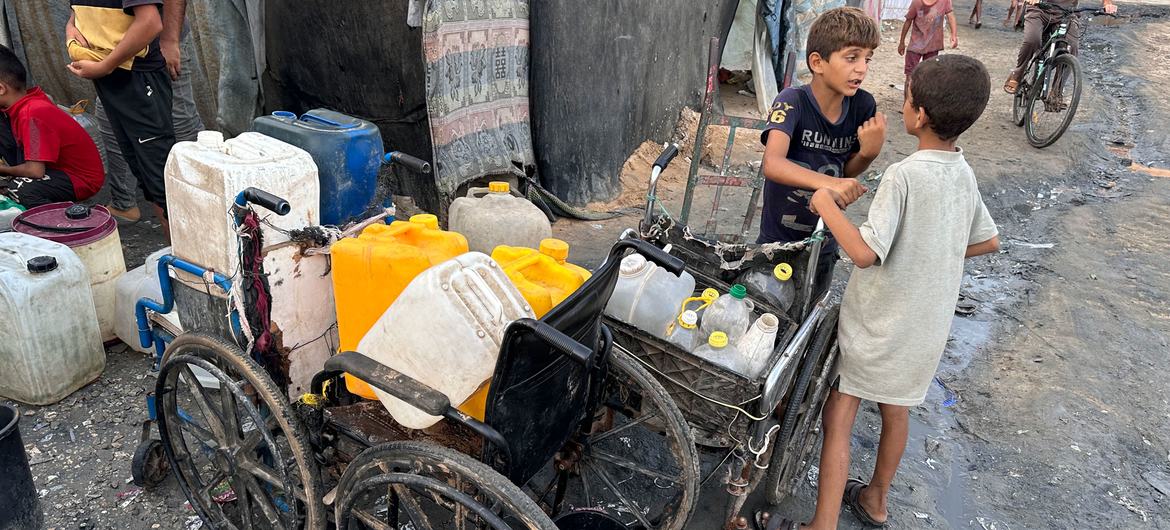 Crianças coletam água na Faixa de Gaza.