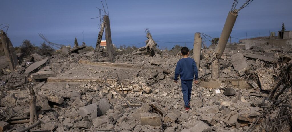 Um menino de 5 anos caminha por prédios destruídos em Majdal Zoun, no sul do Líbano