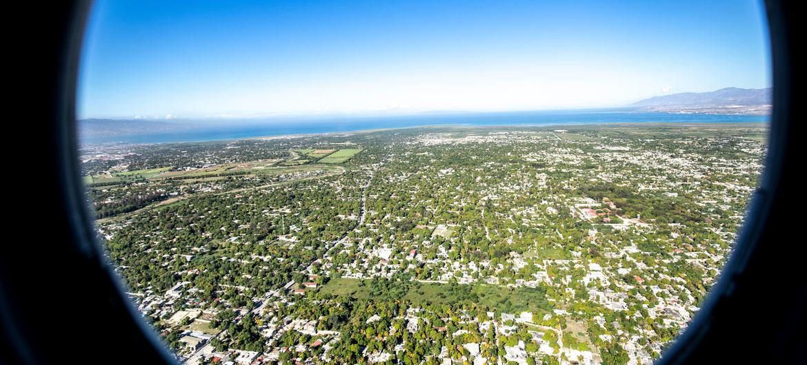 Um helicóptero sobrevoa uma área urbana no Haiti