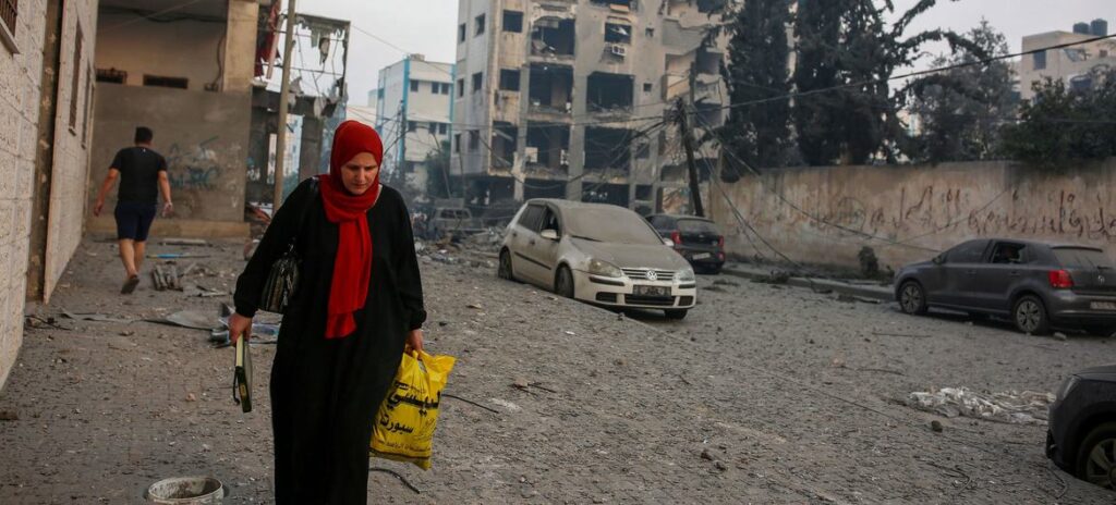 Uma mulher caminha ao lado de sua casa destruída na área do Estádio Palestina, no centro da cidade de Gaza (arquivo)