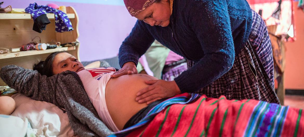 Mulher grávida na Guatemala recebe cuidados de um profissional de saúde.