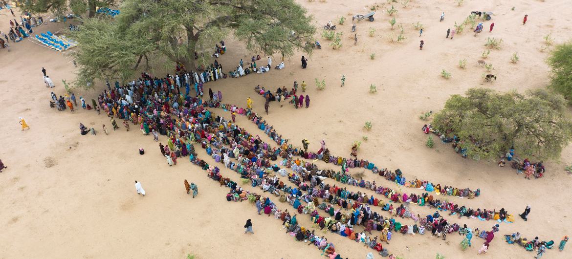 Pessoas deslocadas pelo conflito no Sudão fazem fila para receber ajuda ao chegar ao Chade