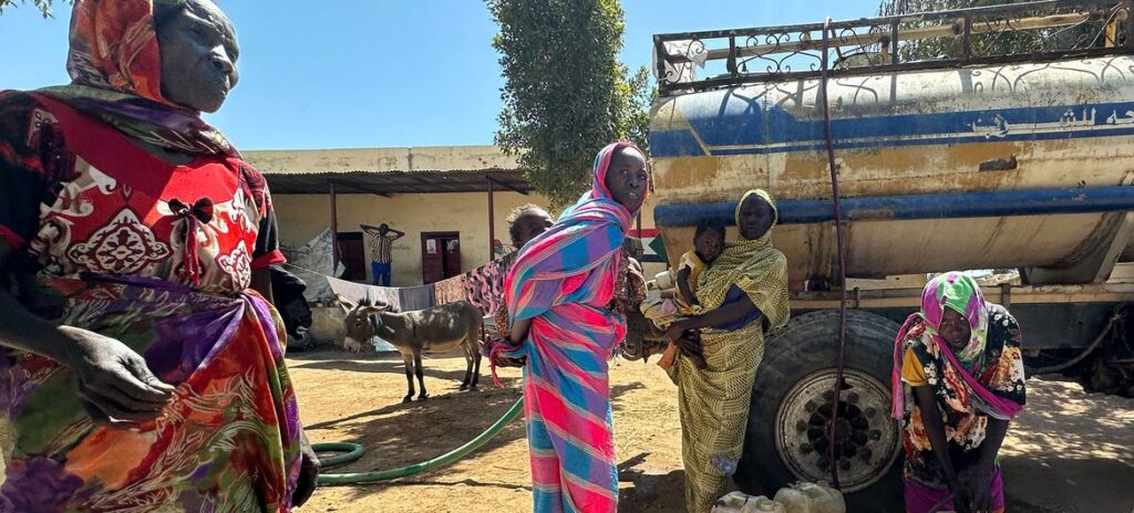 Pessoas deslocadas no campo de Darfur coletando água.