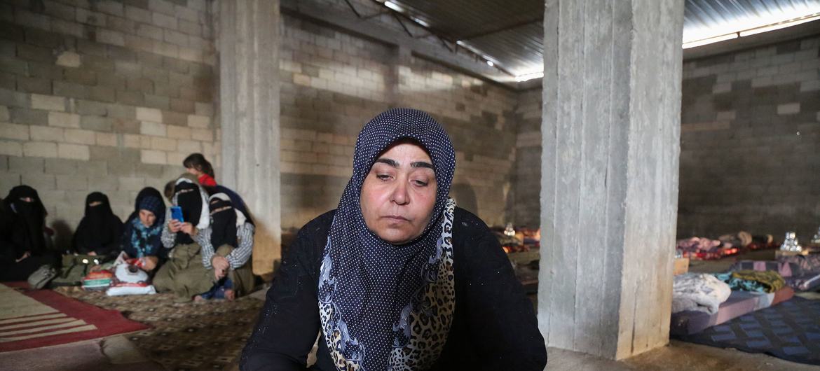 Uma mulher está em um abrigo para pessoas deslocadas depois de fugir de sua casa no norte da Síria