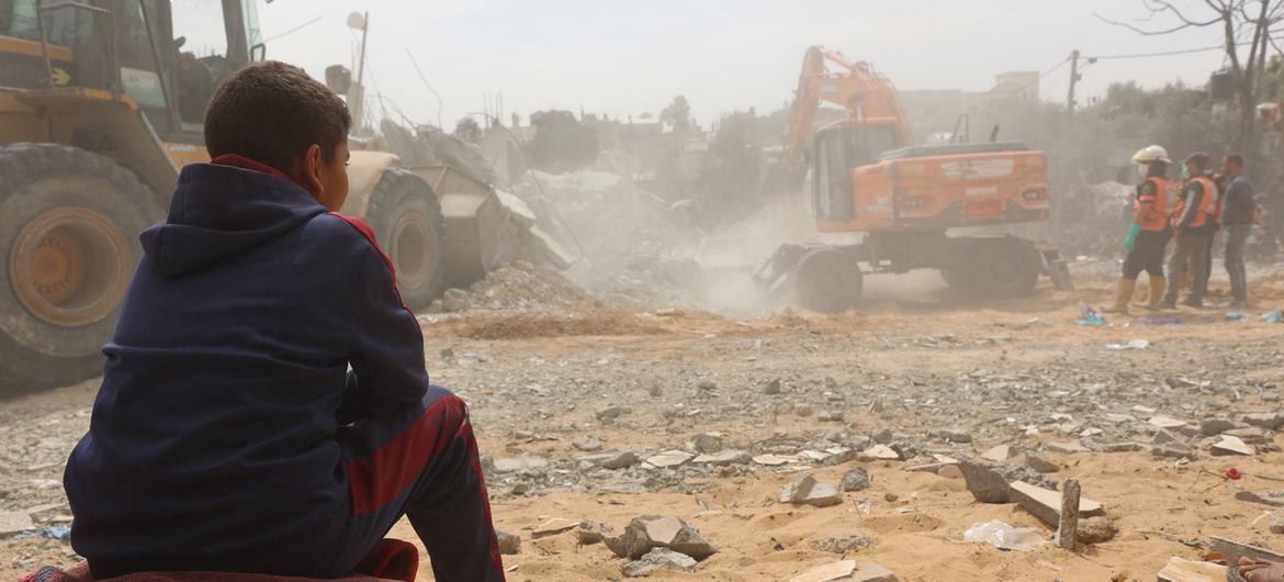 Uma criança acompanha/observa a recuperação de corpos debaixo dos escombros de uma casa no bairro de Al-Nasr, a leste da cidade de Rafah, no sul da Faixa de Gaza