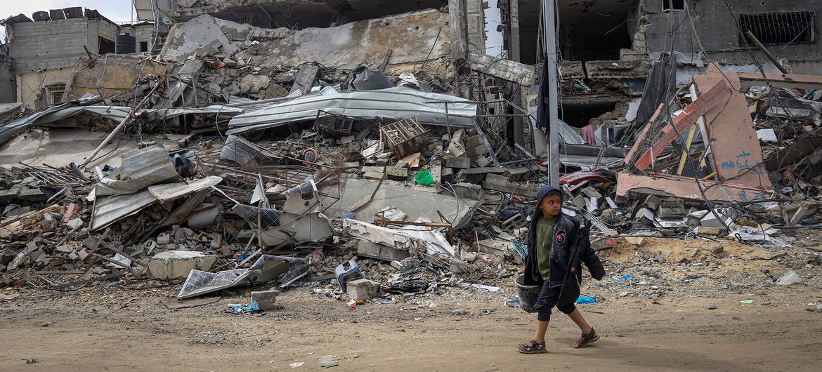 Um menino caminha pelos escombros de seu bairro em Khan Younis, no sul de Gaza