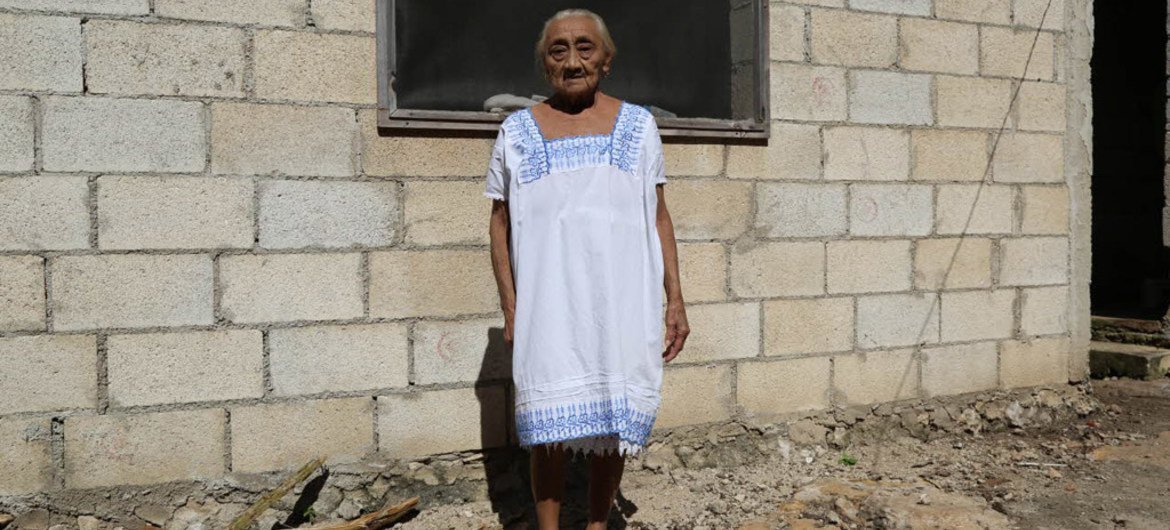 Idosa posando em frente à sua casa em Chagas, no México, onde foram instaladas cortinas impregnadas de longa duração para manter a casa livre dos insetos triamatones