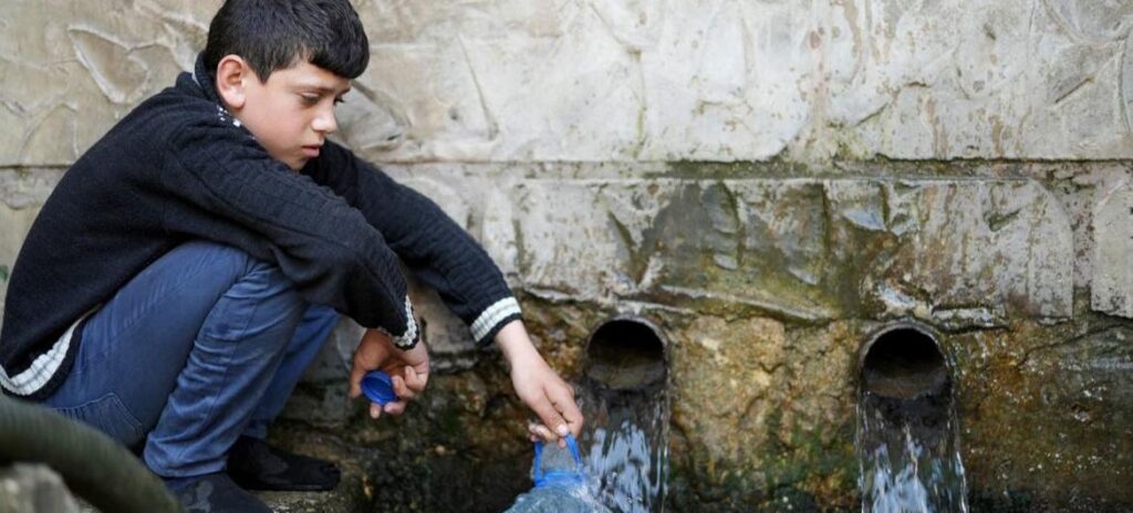 Um menino de 11 anos coleta água de um poço em Wadi El Jamous, no Líbano