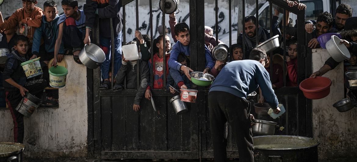 Crianças esperam para receber comida em Rafah, no sul da Faixa de Gaza