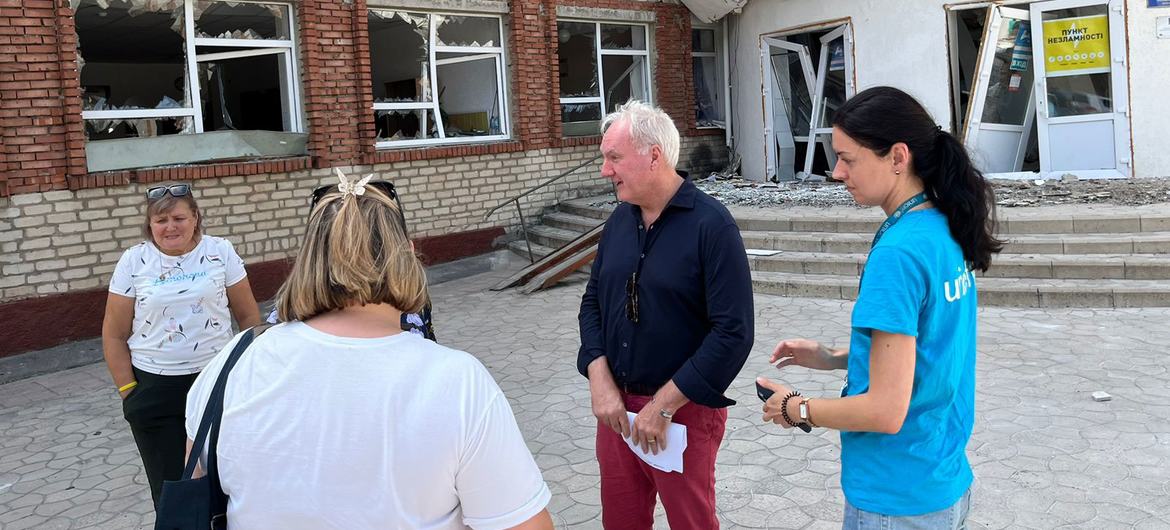 O coordenador humanitário da Ucrânia, Matthias Schmale (segundo da direita para a esquerda), em frente a um centro de trânsito para pessoas deslocadas que fogem das hostilidades na região de Donetsk, na linha de frente.