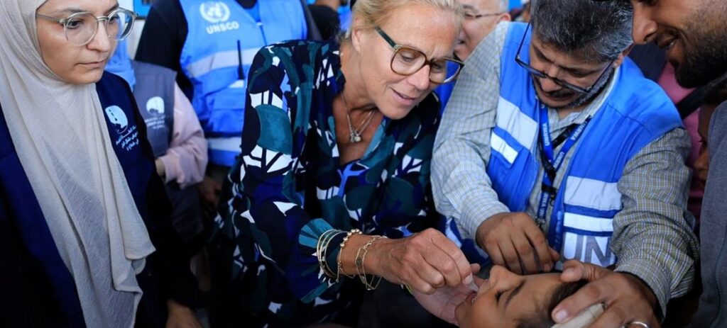 Sigrid Kaag, Coordenadora Sênior Humanitária e de Reconstrução para Gaza, administra uma dose da vacina contra a pólio em uma criança em Gaza.