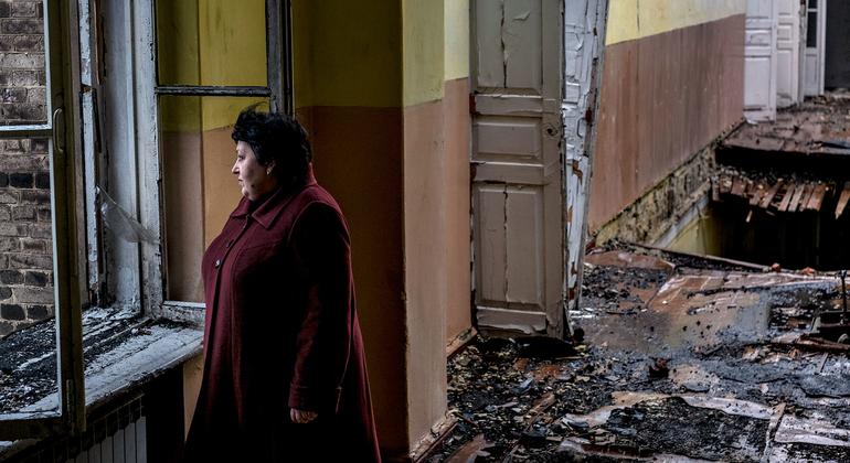 Uma mulher está em uma escola abandonada após ter sido danificada num em Krasnohorivka, na área ucraniana Donetsk